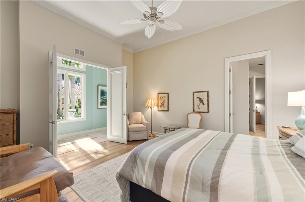 9264 Sweetgrass Way Naples, FL 34108 - Photo 28 of 40 a bedroom with a bed and wooden floor