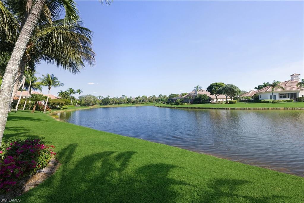 9264 Sweetgrass Way Naples, FL 34108 - Photo 33 of 40 a view of a lake with houses in the back