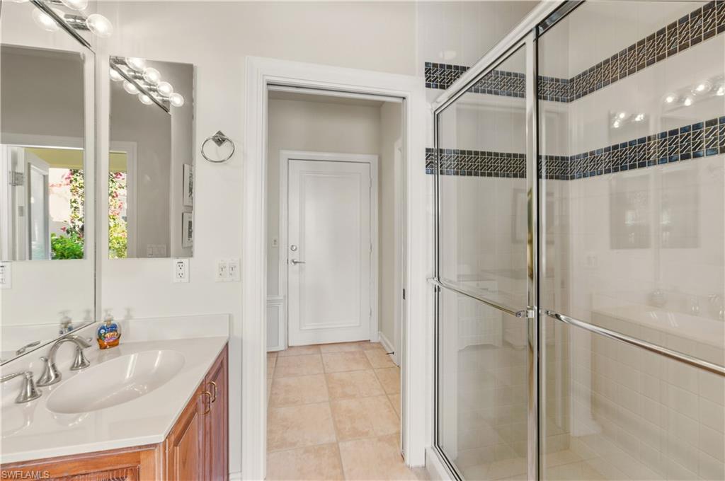 9264 Sweetgrass Way Naples, FL 34108 - Photo 36 of 40 a bathroom with a shower sink vanity and mirror