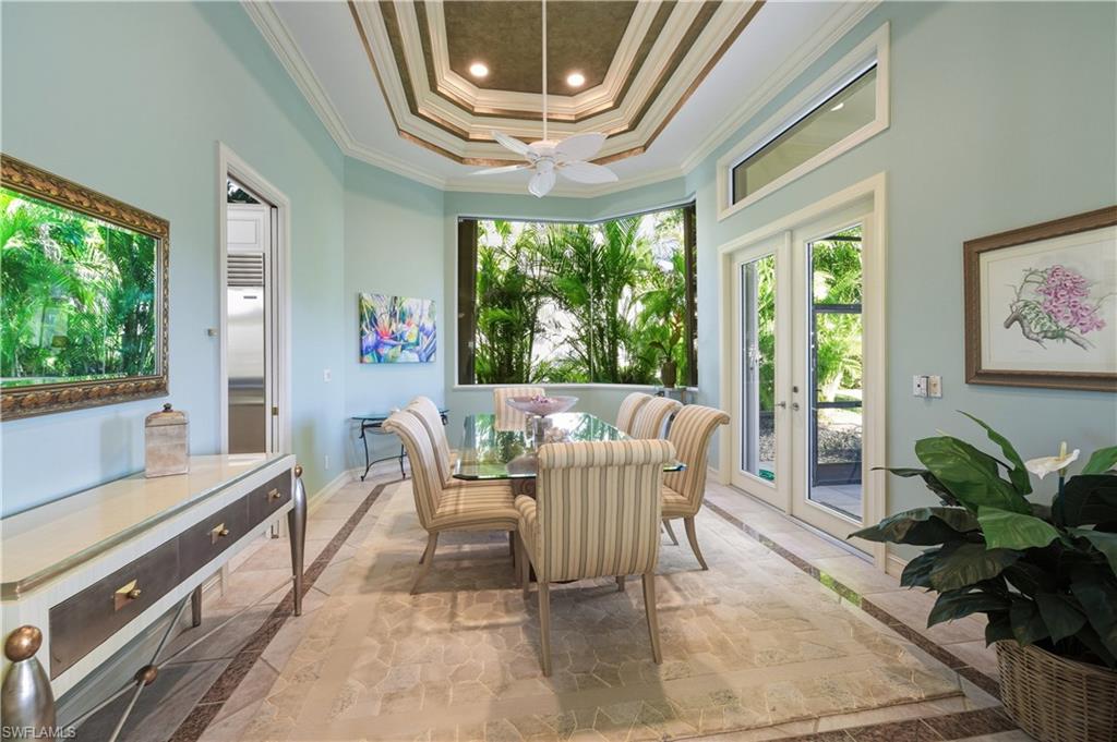 9264 Sweetgrass Way Naples, FL 34108 - Photo 5 of 40 a dining room with furniture a chandelier and wooden floor