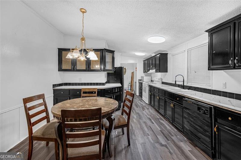 473 Haley Road Jackson, GA 30233 - Photo 11 of 13 a kitchen with stainless steel appliances a dining table chairs sink and stove top oven