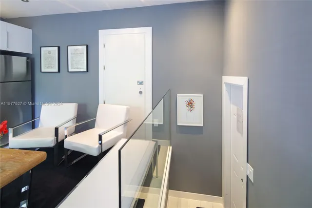 a living room with stainless steel appliances furniture a dining table and kitchen view