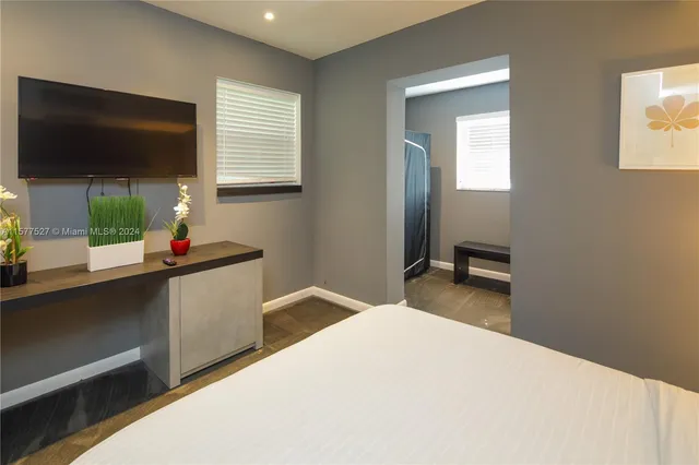 a bedroom with a bed and a flat screen tv