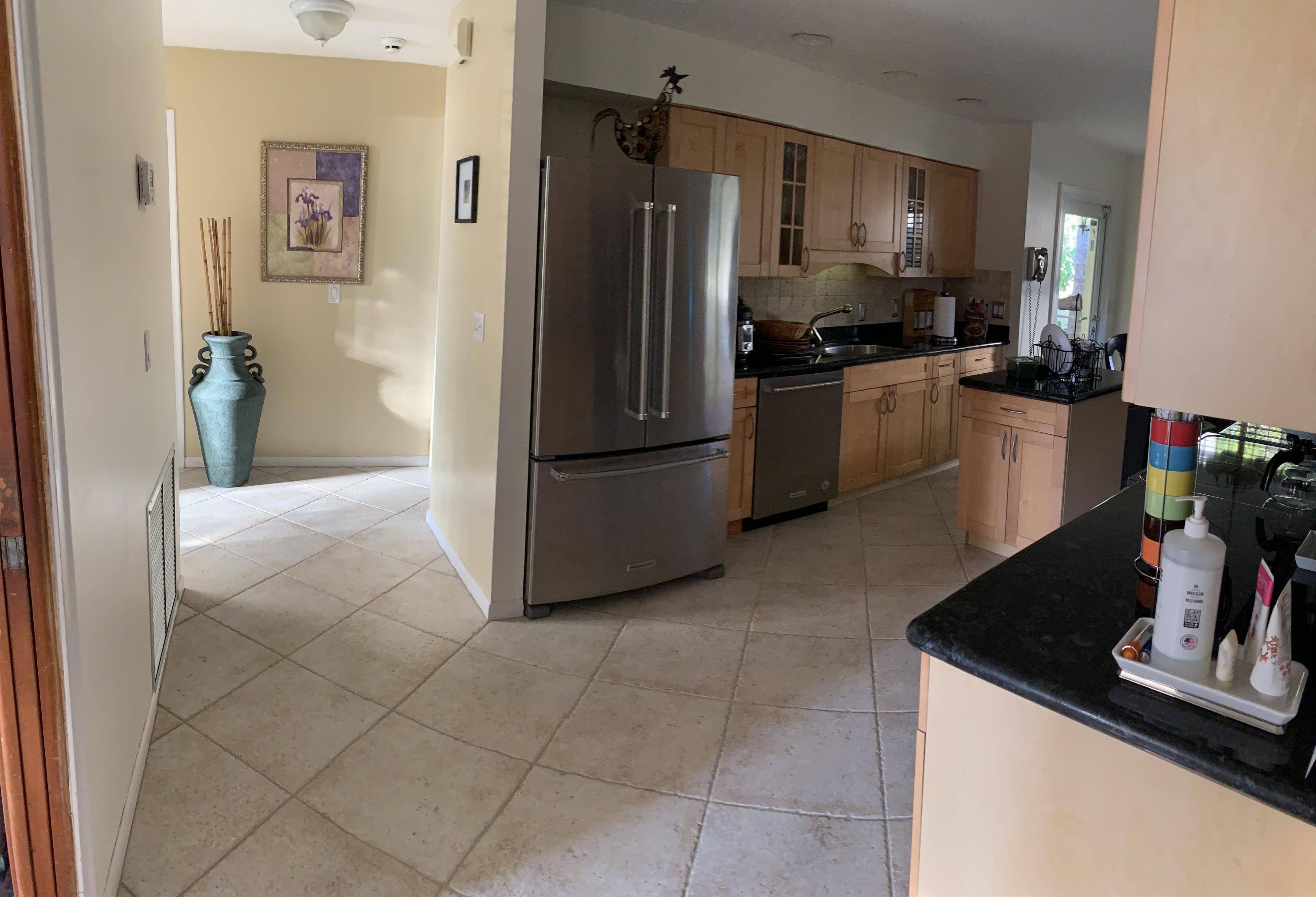 255 Cortez Road West Palm Beach, FL 33405 - Photo 9 of 26 a kitchen with a refrigerator a stove top oven a counter space and a window