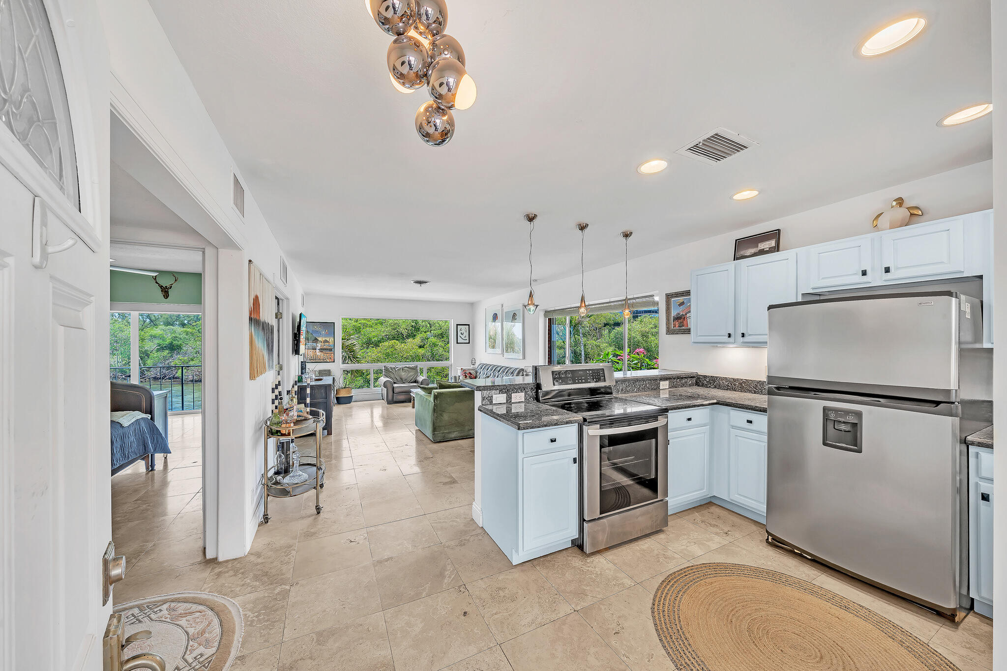 711 Northeast Harbour Terrace, Unit 4120 Boca Raton, FL 33431 - Photo 3 of 37 a kitchen with a refrigerator a stove top oven a sink dishwasher and white cabinets with wooden floor