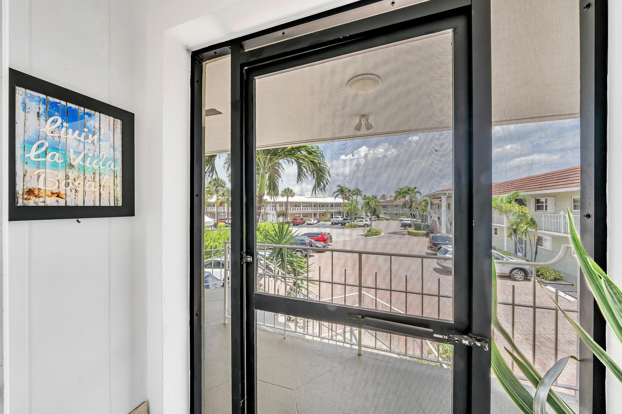 711 Northeast Harbour Terrace, Unit 4120 Boca Raton, FL 33431 - Photo 32 of 37 a view of a glass door with a tree from a window