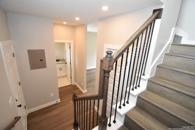 a view of a hallway with wooden floor and stairs