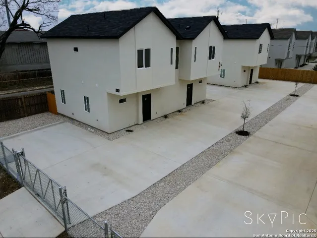 a view of a white house with a large space in front of it