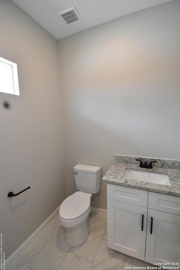 6402 Tahoka Road San Antonio, TX 78227 - Photo 7 of 21 a bathroom with a granite countertop toilet and a sink