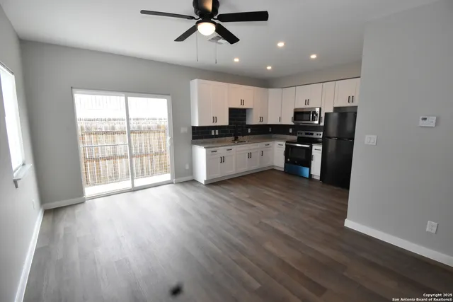 a large kitchen with stainless steel appliances wooden floors and wooden cabinets