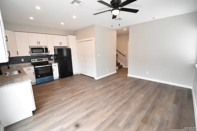 a kitchen with stainless steel appliances kitchen island granite countertop a refrigerator and a stove top oven