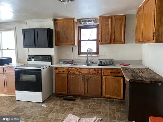 a kitchen with a sink stove top oven and cabinets