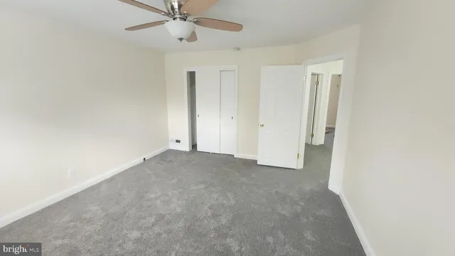 an empty room with a ceiling fan and a window