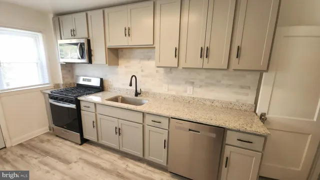 a kitchen with granite countertop white cabinets and white appliances