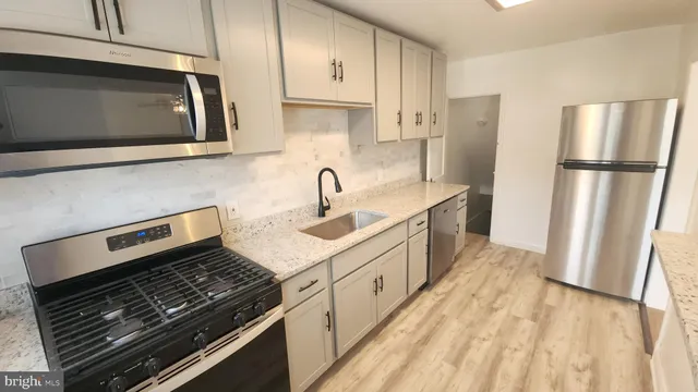 a kitchen with stainless steel appliances a stove microwave and sink