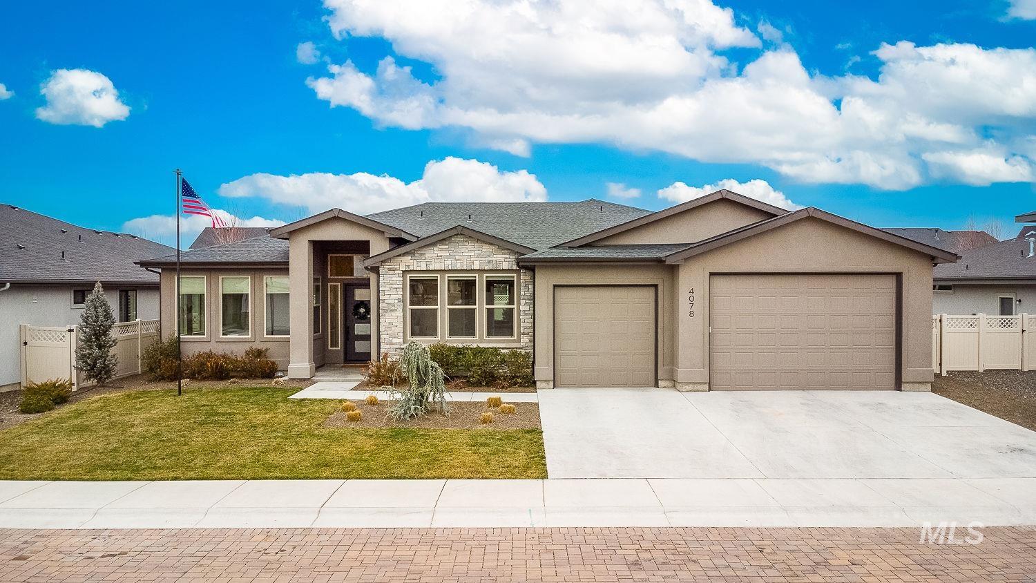 Ranch-style home featuring concrete driveway, a garage, stucco siding, and stone siding