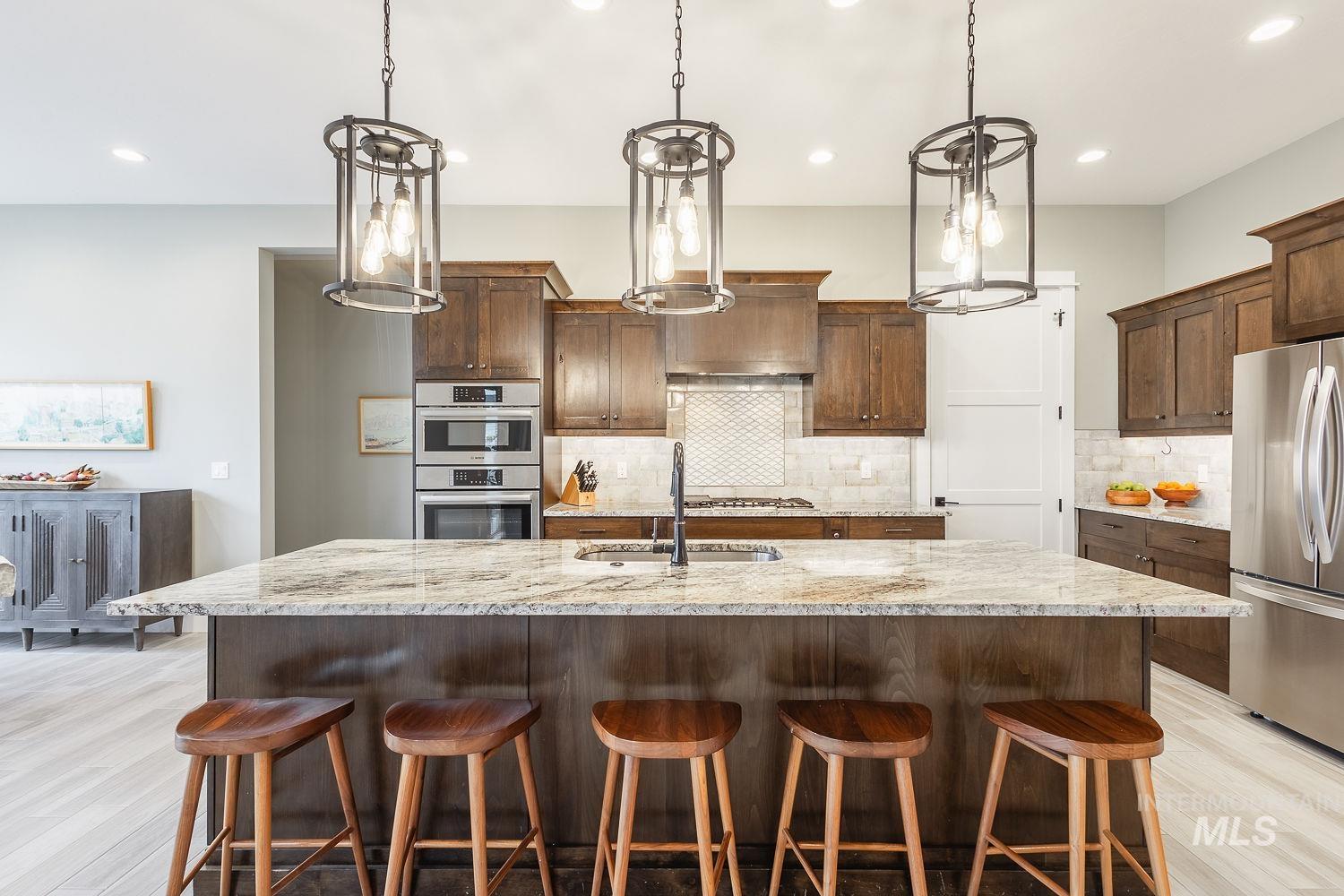 4078 West Wapoot Street Meridian, ID 83646 - Photo 11 of 46 Kitchen featuring light wood-style floors, appliances with stainless steel finishes, a kitchen bar, light stone countertops, and recessed lighting