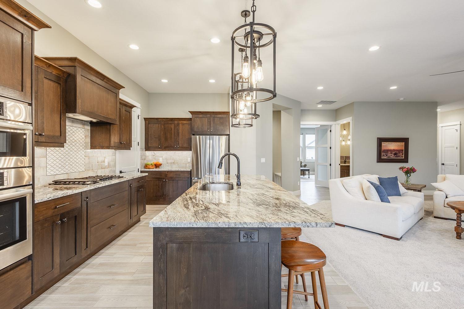 4078 West Wapoot Street Meridian, ID 83646 - Photo 12 of 46 Kitchen featuring light stone countertops, a large island, hanging light fixtures, a breakfast bar, and recessed lighting
