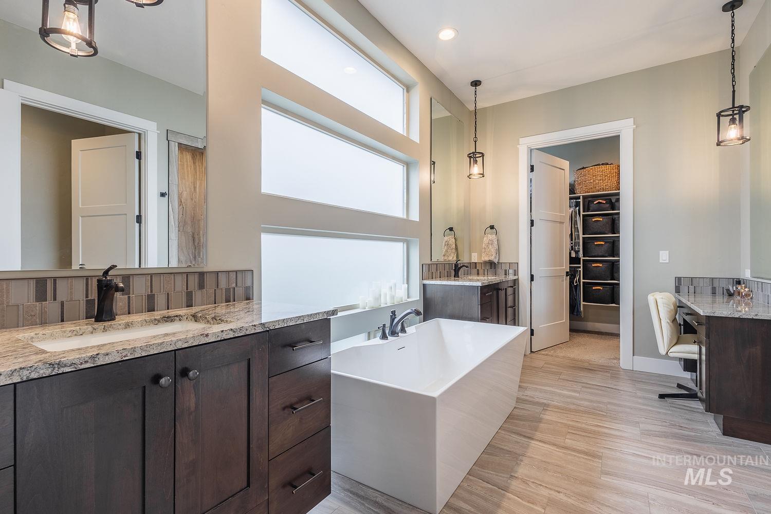 4078 West Wapoot Street Meridian, ID 83646 - Photo 21 of 46 Full bathroom featuring two vanities, a walk in closet, backsplash, and light wood-type flooring