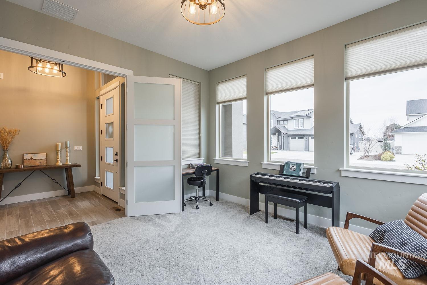 4078 West Wapoot Street Meridian, ID 83646 - Photo 26 of 46 Living area featuring light carpet, wood finish floors, and a chandelier