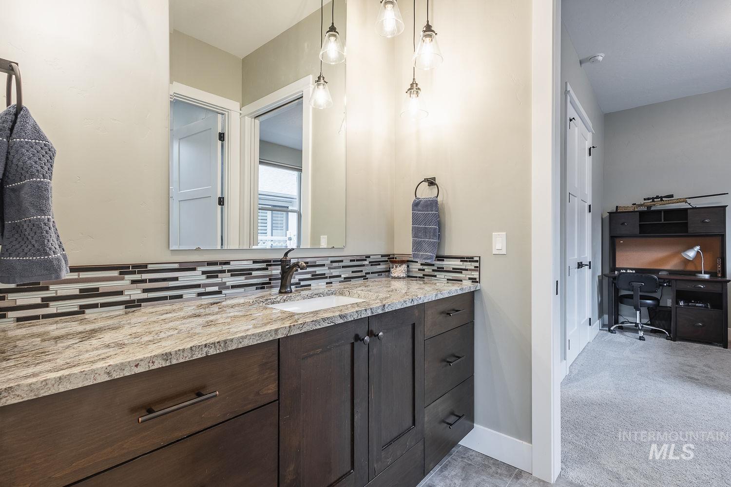 4078 West Wapoot Street Meridian, ID 83646 - Photo 30 of 46 Bathroom with vanity, light carpet, and decorative backsplash