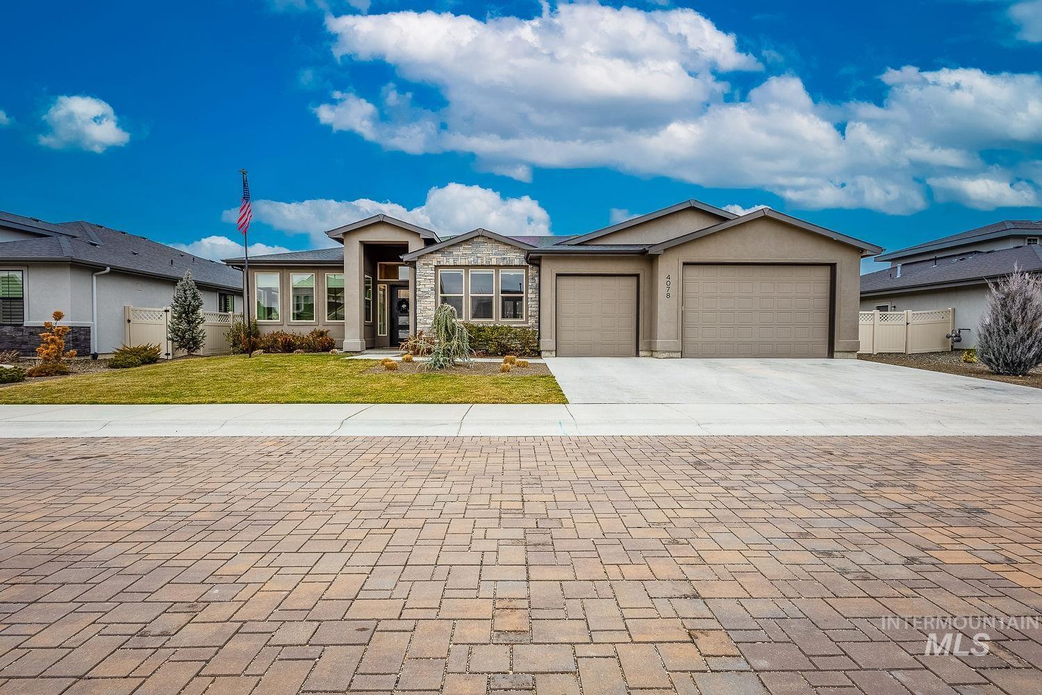 4078 West Wapoot Street Meridian, ID 83646 - Photo 3 of 46 Ranch-style home featuring stucco siding, stone siding, concrete driveway, and a garage