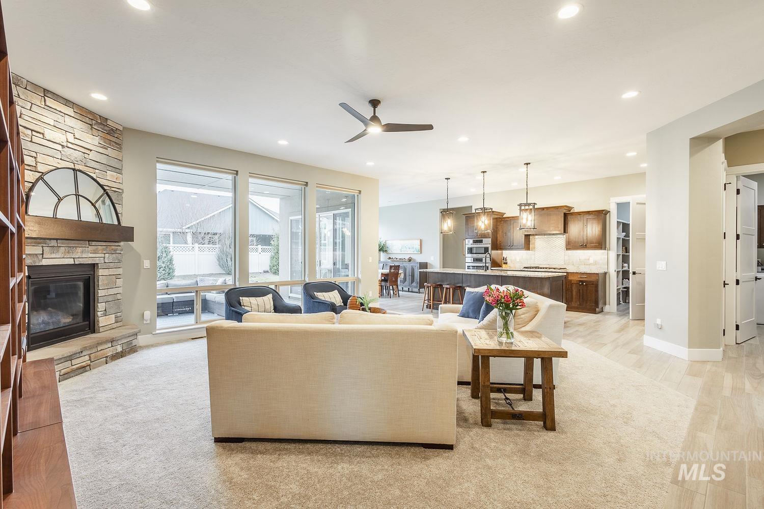 4078 West Wapoot Street Meridian, ID 83646 - Photo 7 of 46 Living room with a ceiling fan, a stone fireplace, recessed lighting, and light wood-type flooring