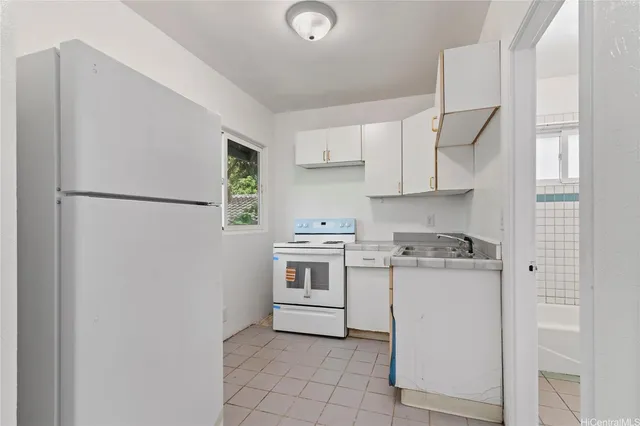 a kitchen with stainless steel appliances granite countertop a refrigerator sink and white cabinets