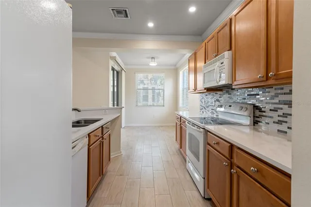 a kitchen with stainless steel appliances granite countertop a sink stove and cabinets