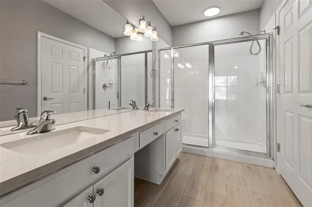 a bathroom with a double vanity sink mirror double and shower