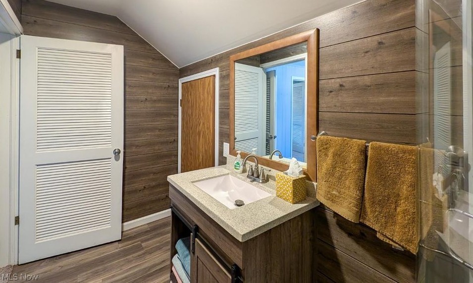 41 Poplar Street Huron, OH 44839 - Photo 20 of 37 Bathroom featuring wood walls, vanity, lofted ceiling, and wood style flooring
