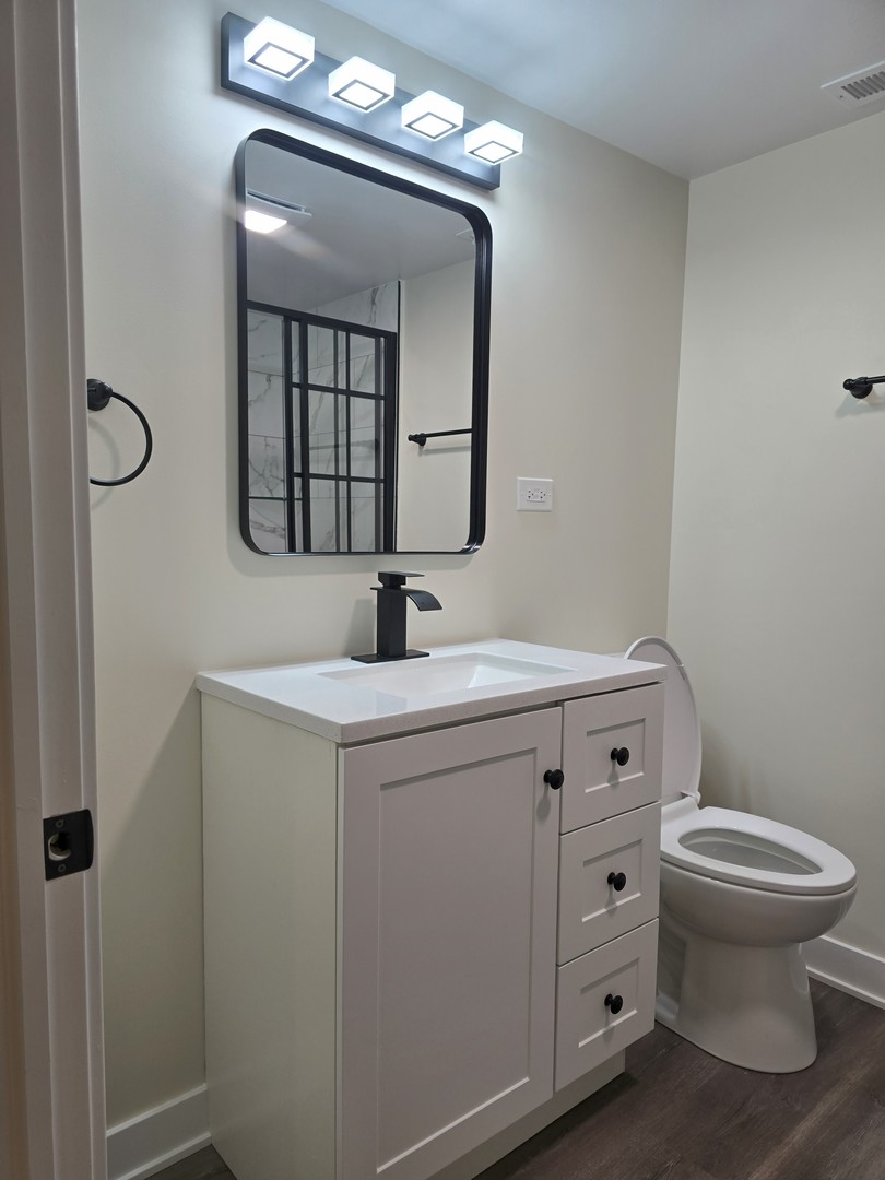 7740 West Norwood Street Chicago, IL 60631 - Photo 12 of 24 a bathroom with a toilet sink and mirror