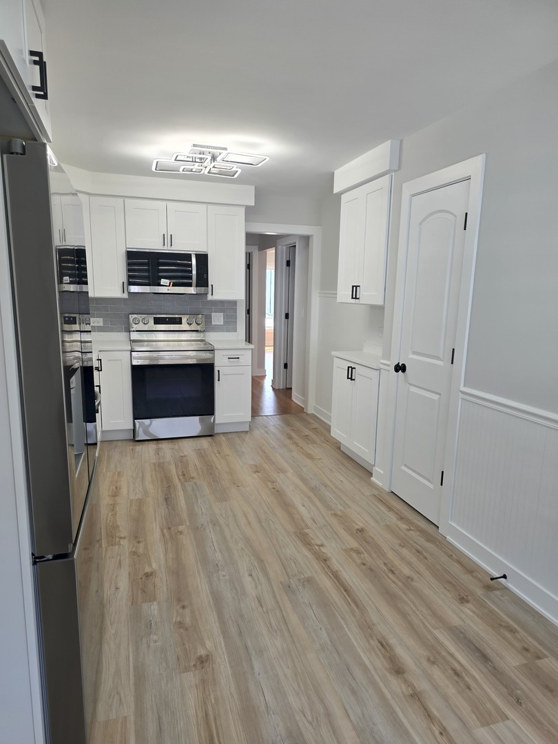 7740 West Norwood Street Chicago, IL 60631 - Photo 4 of 24 a kitchen with stainless steel appliances a refrigerator sink and stove