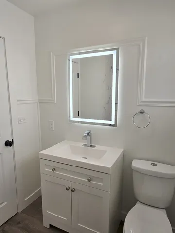 a bathroom with a toilet sink and mirror