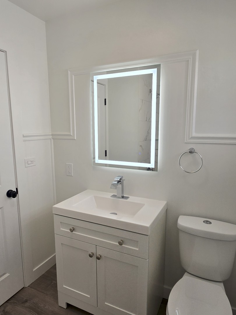 7740 West Norwood Street Chicago, IL 60631 - Photo 6 of 24 a bathroom with a toilet sink and mirror