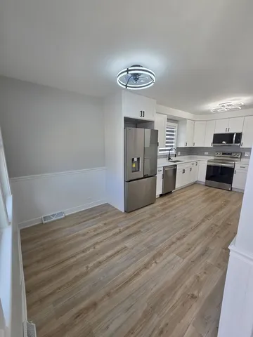 a kitchen with granite countertop a stove cabinets and wooden floor