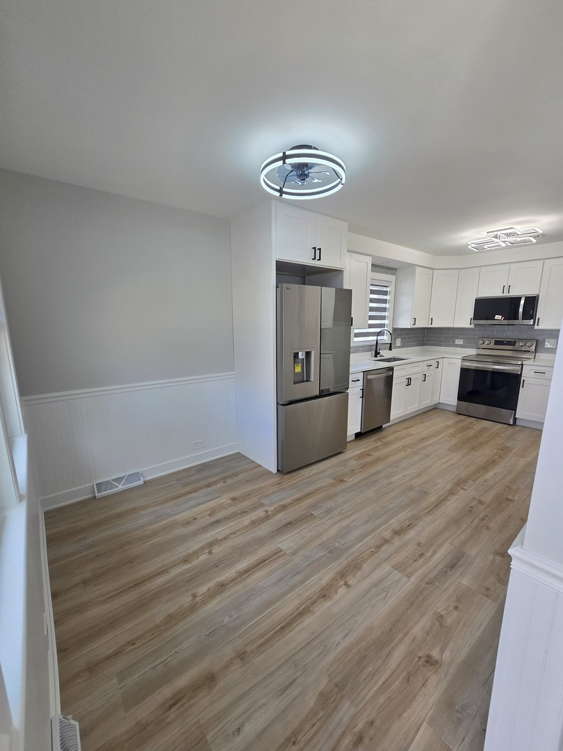 7740 West Norwood Street Chicago, IL 60631 - Photo 9 of 24 a kitchen with granite countertop a stove cabinets and wooden floor