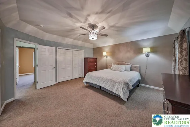 a spacious bedroom with a bed and a chandelier