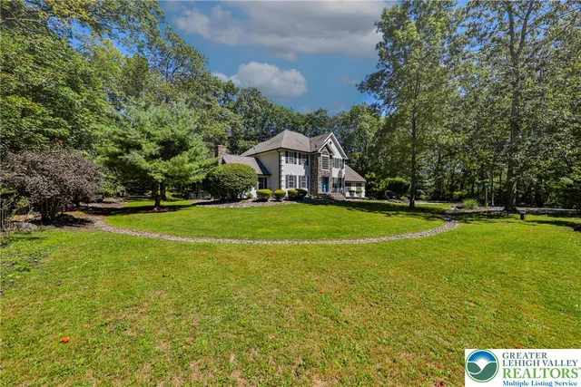 an aerial view of a house with yard and swimming pool