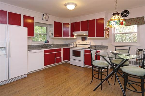 59 Leland Road Brookline, MA 02467 - Photo 5 of 10 a kitchen with stainless steel appliances granite countertop wooden cabinets a stove a sink and a microwave