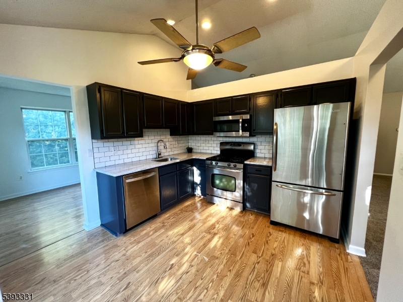 1007 Magnolia Lane Somerville, NJ 08876 - Photo 3 of 13 a kitchen with granite countertop a refrigerator oven a sink dishwasher a dining table and chairs with wooden floor