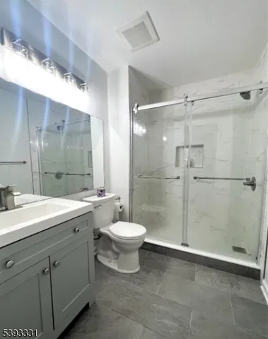 a bathroom with a double vanity sink toilet and shower