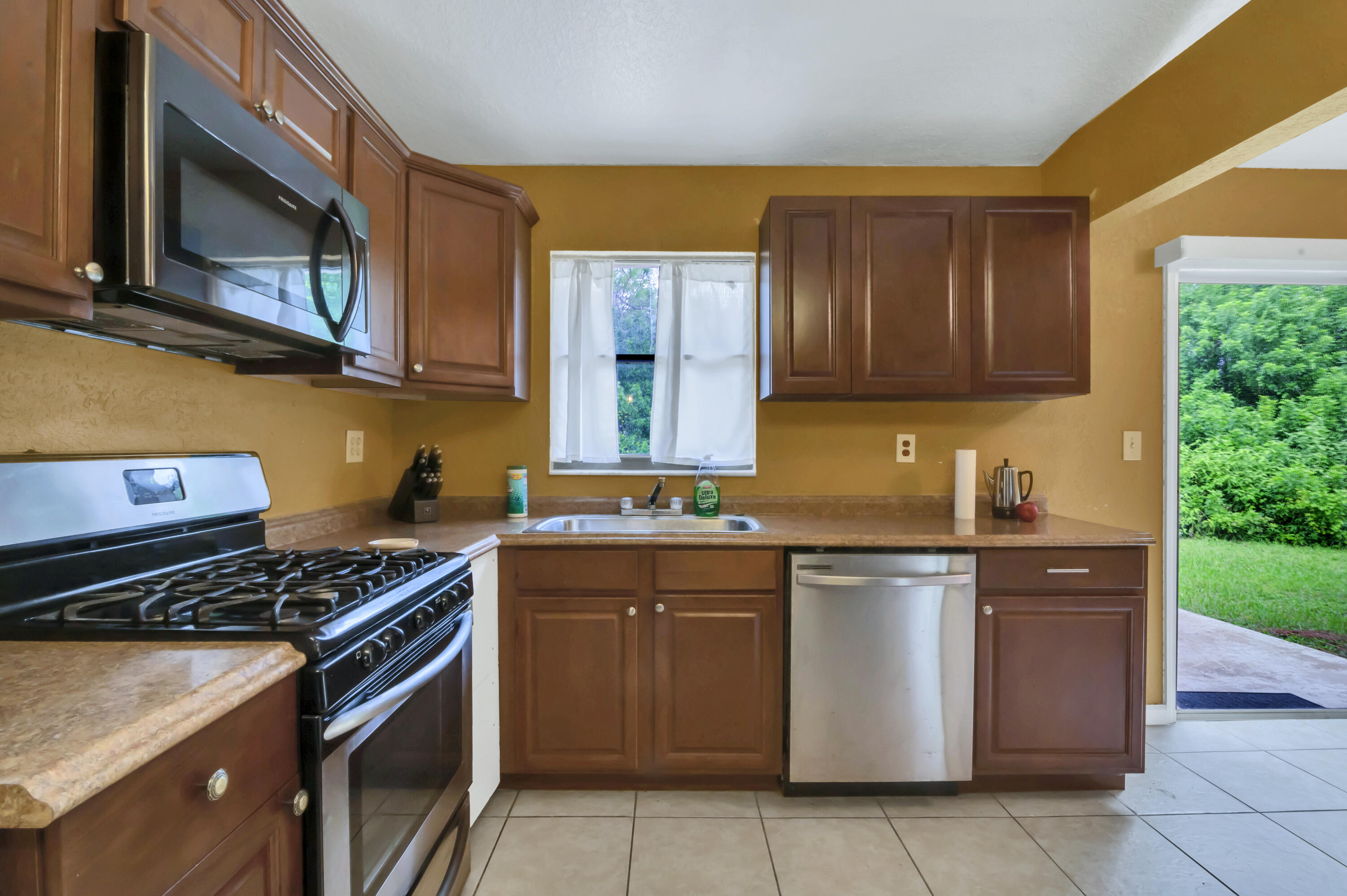 4091 Mandarin Boulevard Loxahatchee, FL 33470 - Photo 12 of 31 a kitchen with stainless steel appliances granite countertop a stove a sink and a microwave