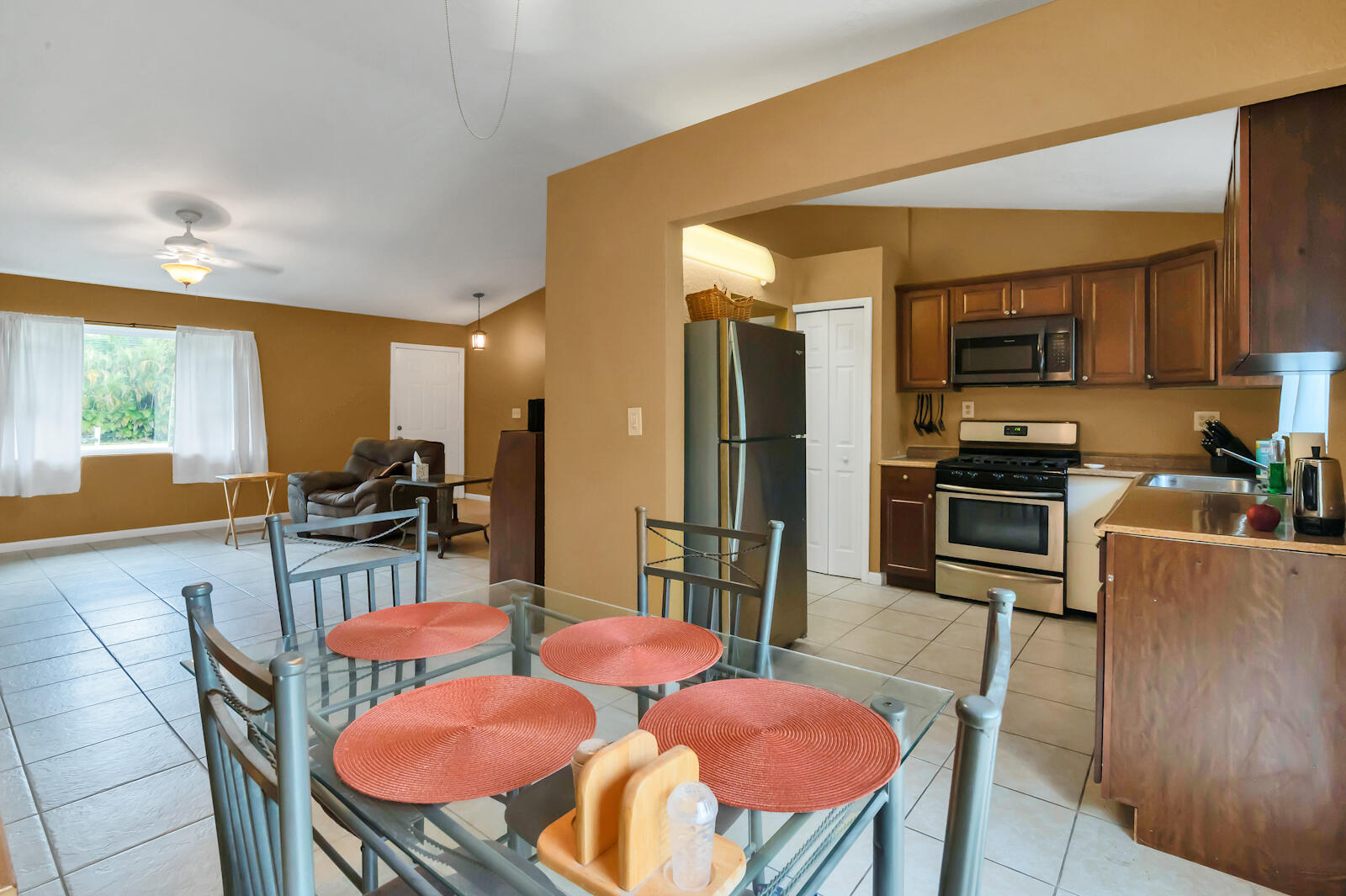 4091 Mandarin Boulevard Loxahatchee, FL 33470 - Photo 10 of 31 a kitchen with stainless steel appliances kitchen island granite countertop a dining table chairs refrigerator and a sink
