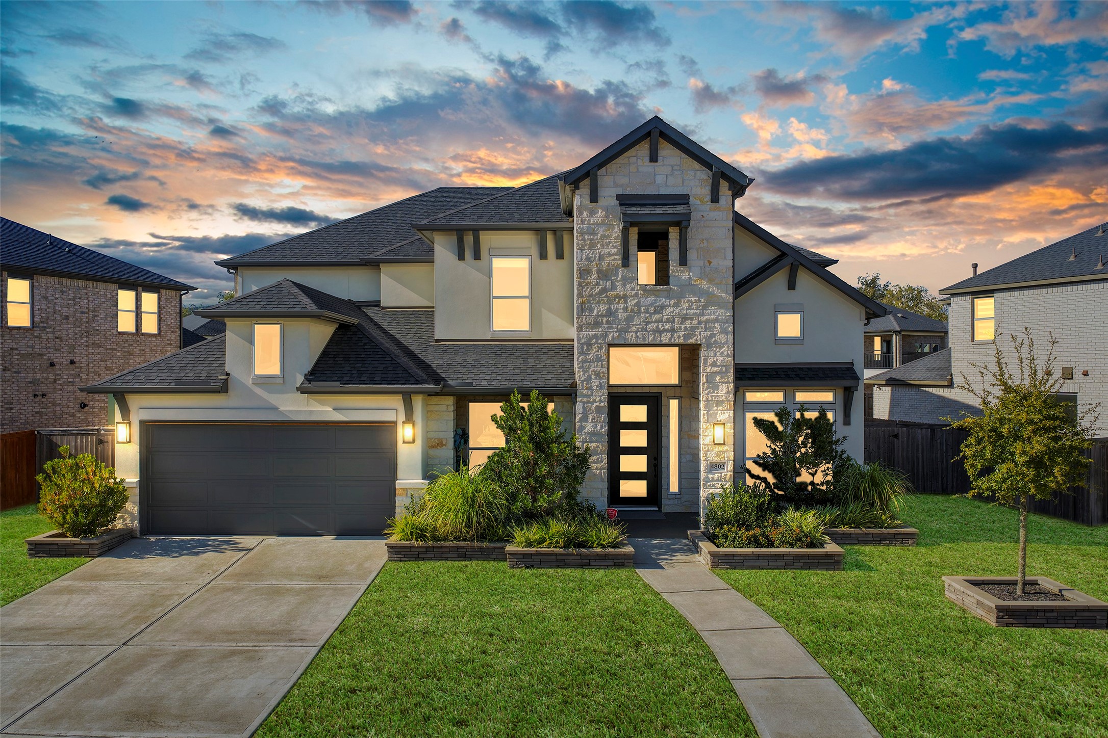 a front view of a house with a yard and potted plants