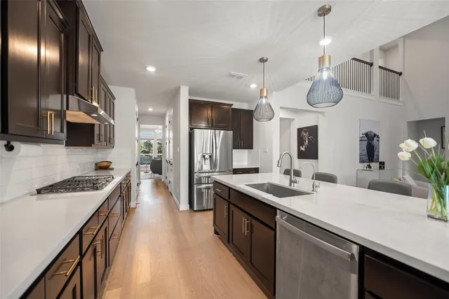 a kitchen with stainless steel appliances a sink stove and refrigerator