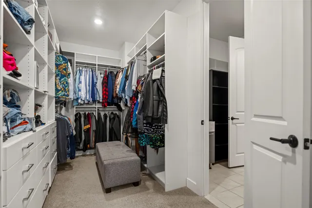 a view of walk in closet with clothes and shoes