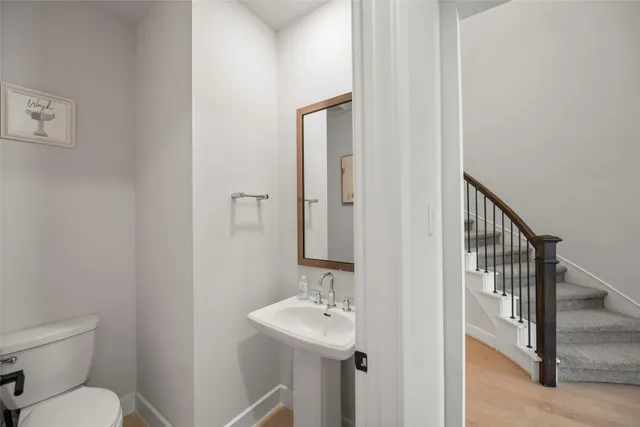 a bathroom with a toilet a sink and mirror