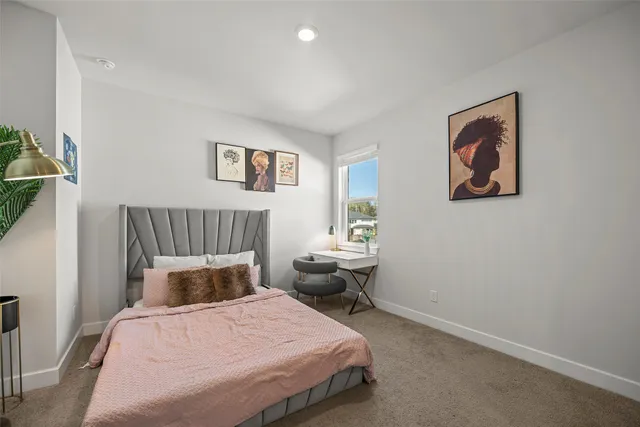 a bedroom with bed and paintings on the wall