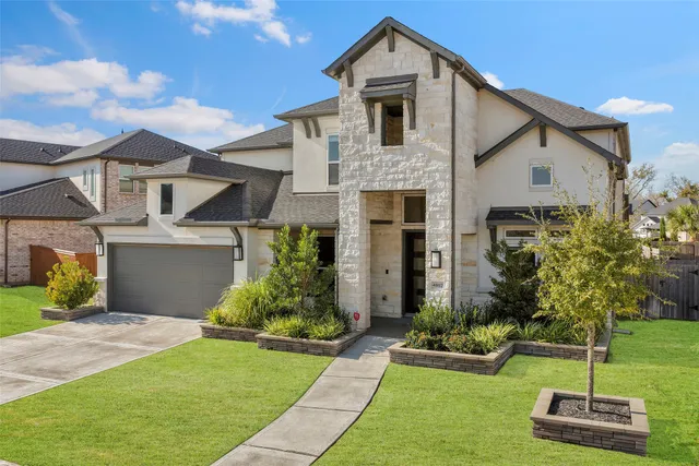 a front view of a house with a yard and garage